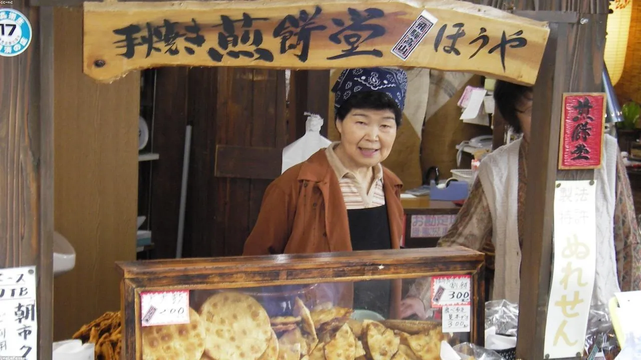 Katsuo-no-tataki being torch-seared at a Tanga Market stall, flame and smoke rising from the bonito